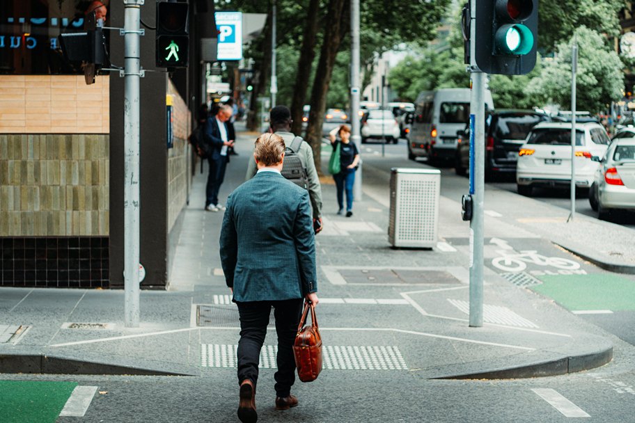 Middle-aged man standing at an intersection and carrying his briefcase. To start a business in middle age, you need to have an entrepreneurial mindset.